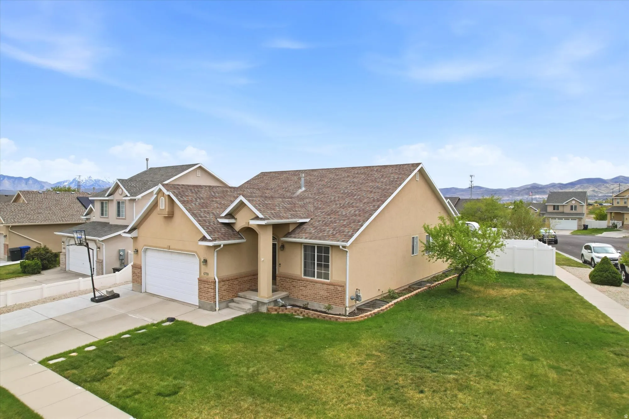 View of front of house with a mountain view, stucco siding, concrete driveway, an attached garage, and a residential view