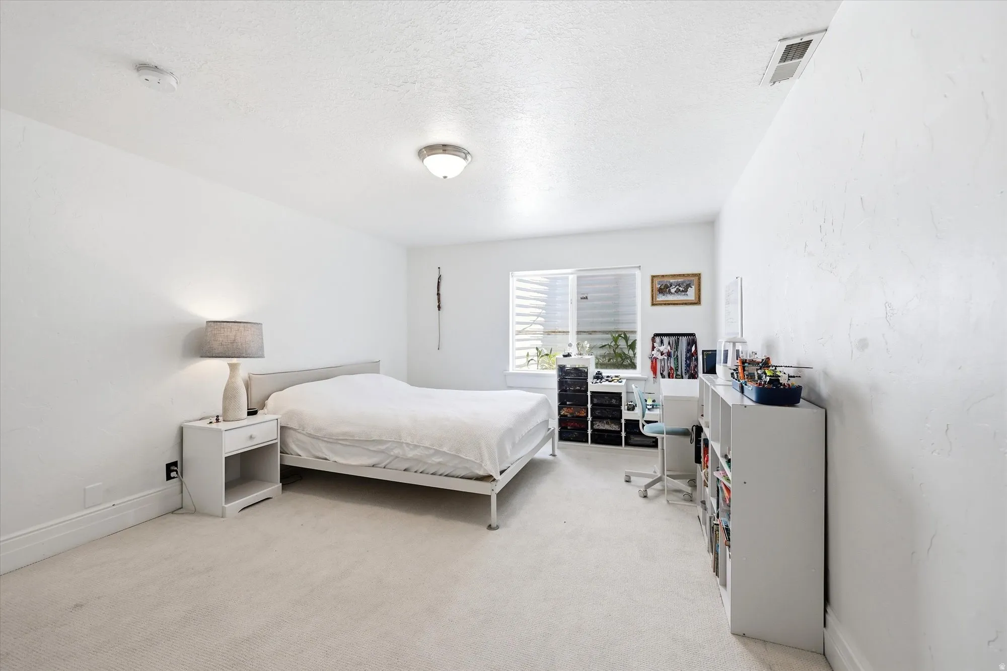 Bedroom featuring light carpet and a textured ceiling