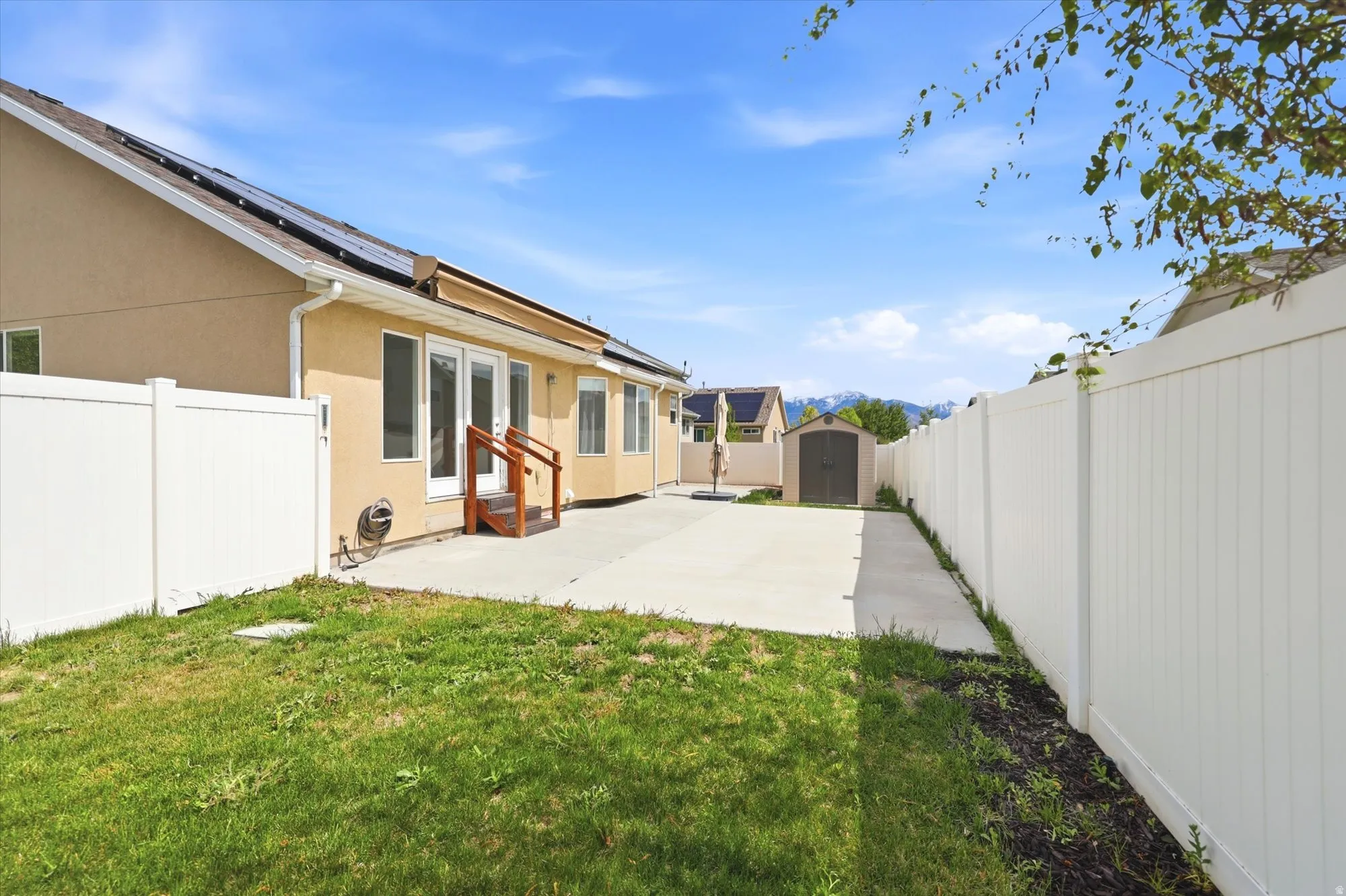 Fenced backyard featuring a shed and a patio