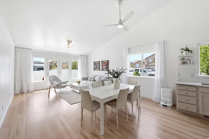 Dining room with lofted ceiling, light wood finished floors, and a ceiling fan