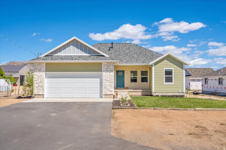 Ranch-style house featuring driveway, a garage, a porch, board and batten siding, and a front lawn