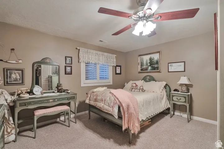 Bedroom with light carpet and a ceiling fan