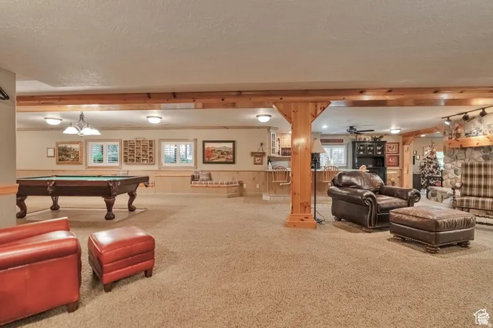 Rec room with carpet flooring, wainscoting, billiards table, ceiling fan, and a textured ceiling