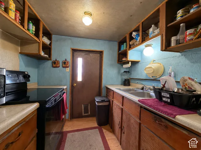 Kitchen featuring wood-finish cabinetry, laminate countertops, and wood-finish flooring