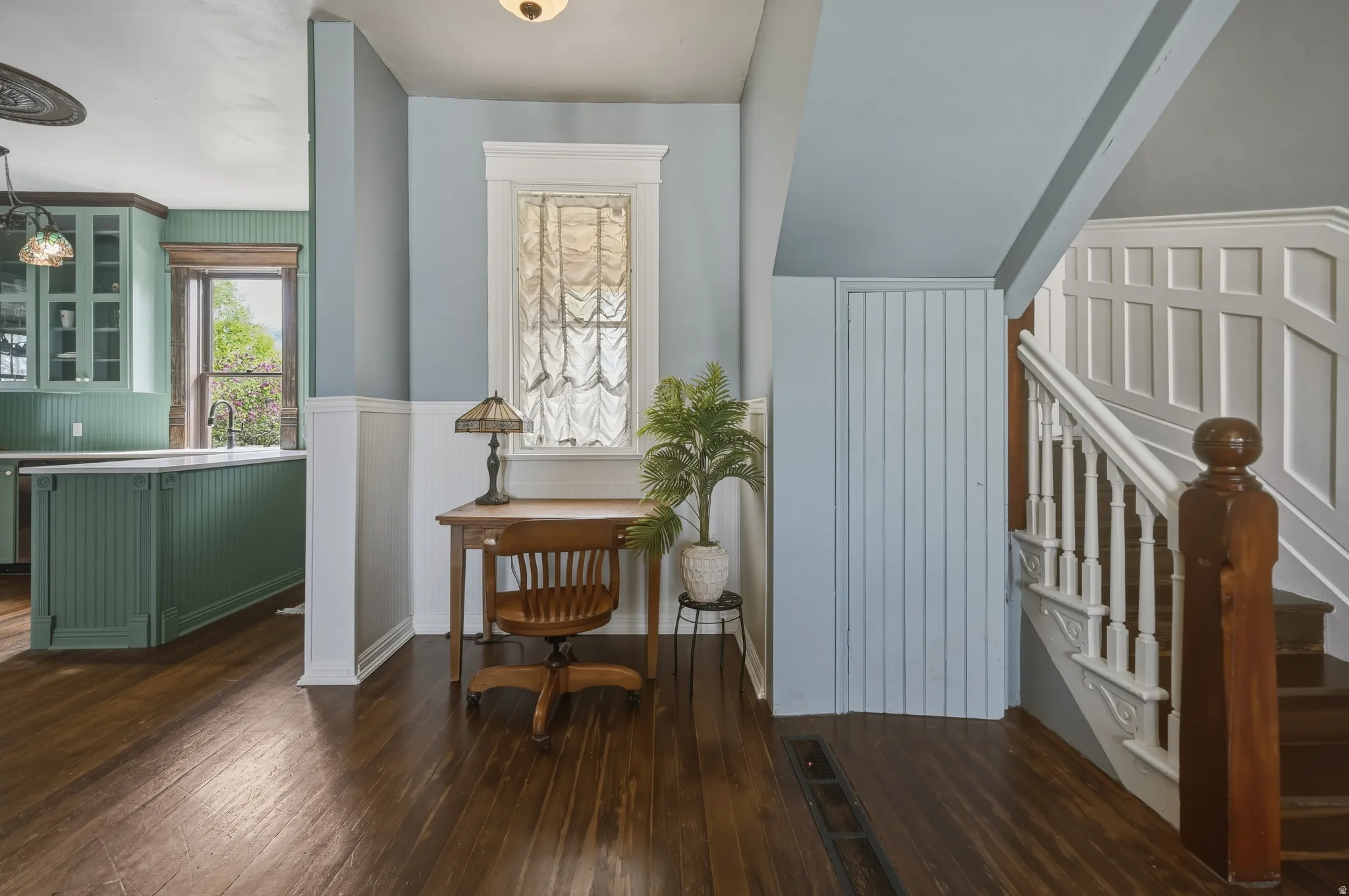 Nook with wainscoted and dark wood flooring