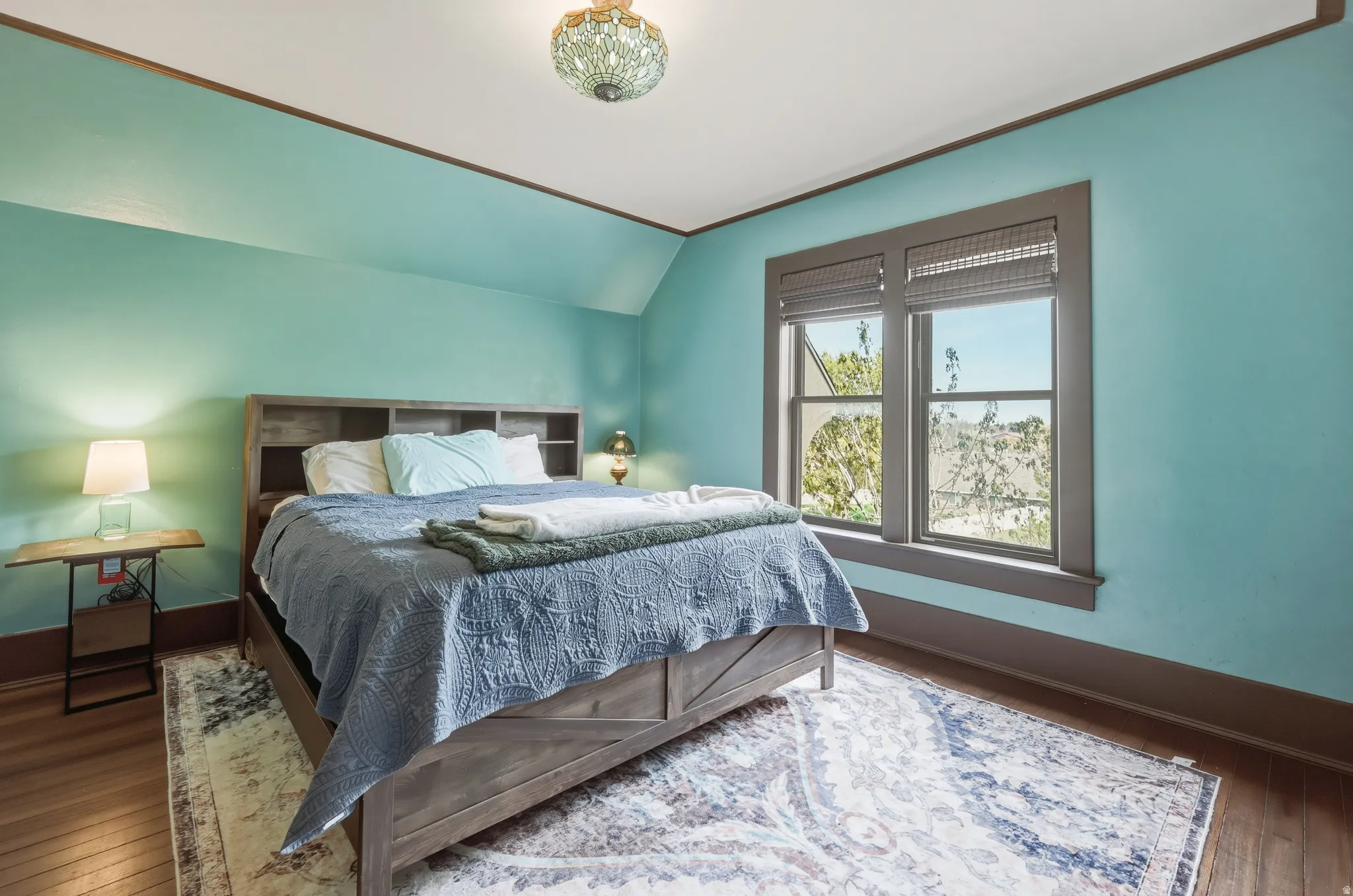 Bedroom with lofted ceiling and view of the backyard, his and her closets