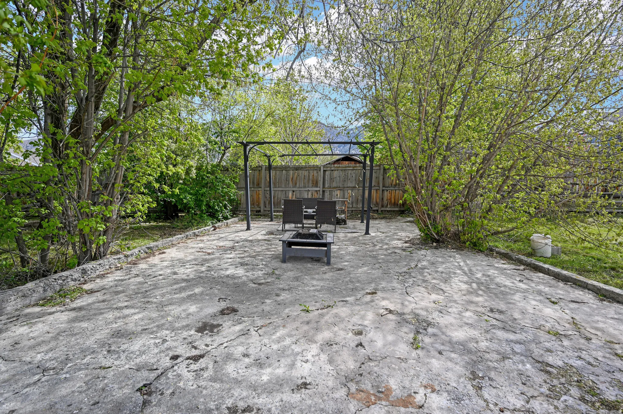 Fenced backyard featuring a patio area, pergola & fire pit
