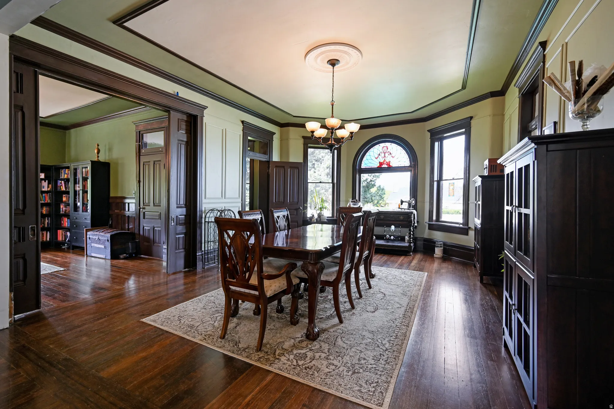 Formal dining area with chandelier, crown molding, and bay window