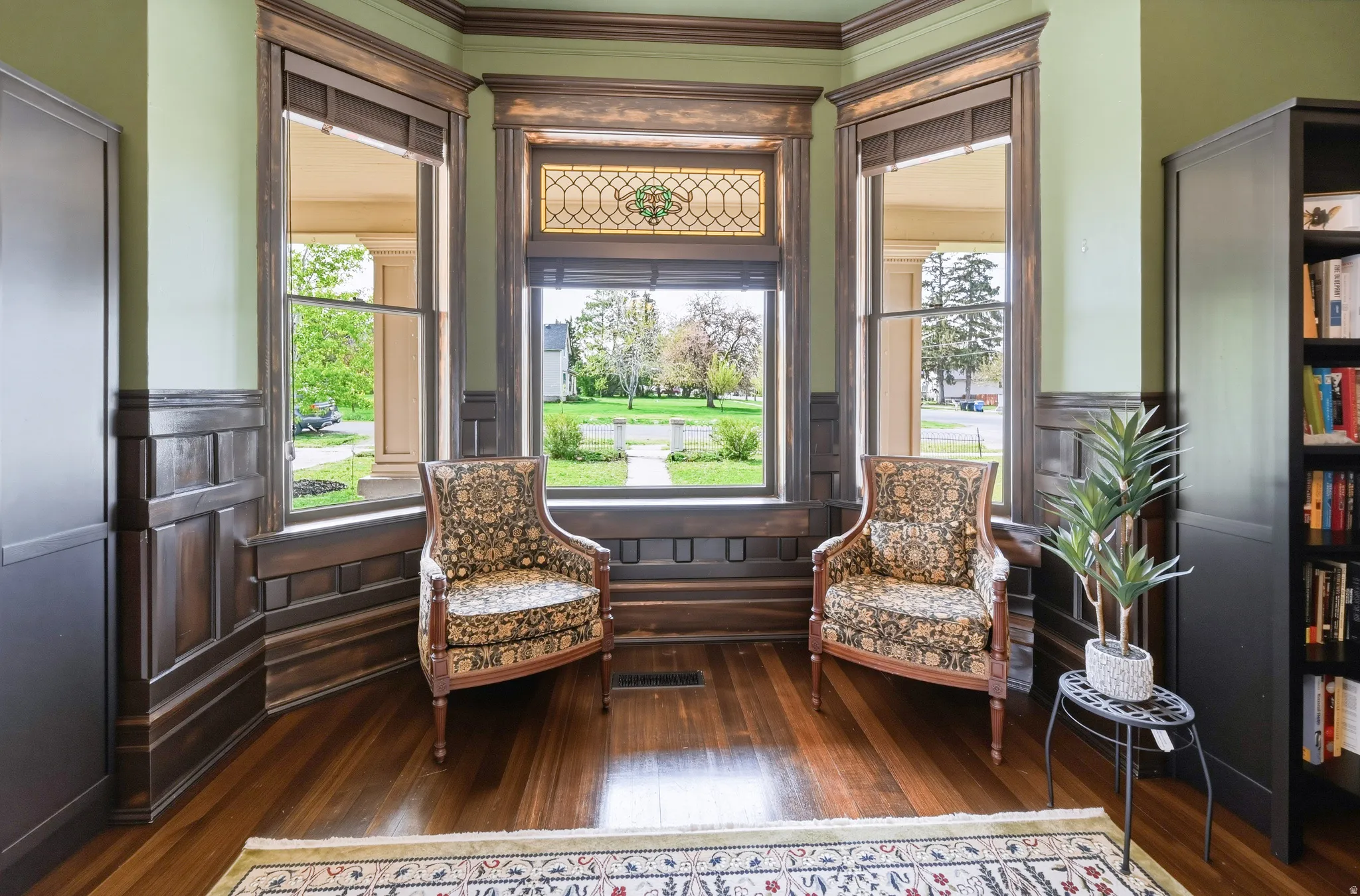 Bay window, dark wood flooring, crown molding