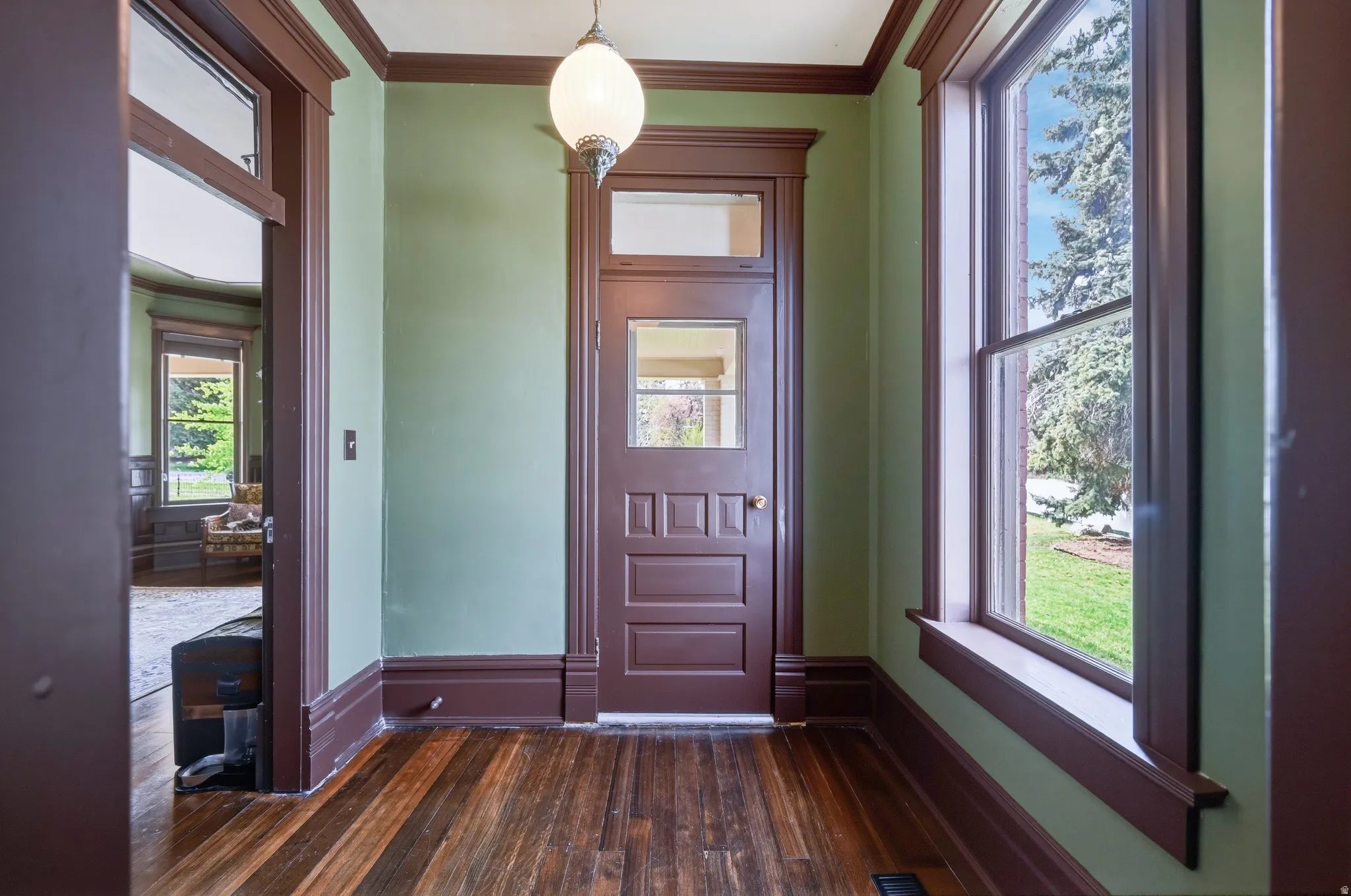 Formal entryway with dark wood flooring and hand-stained crown molding