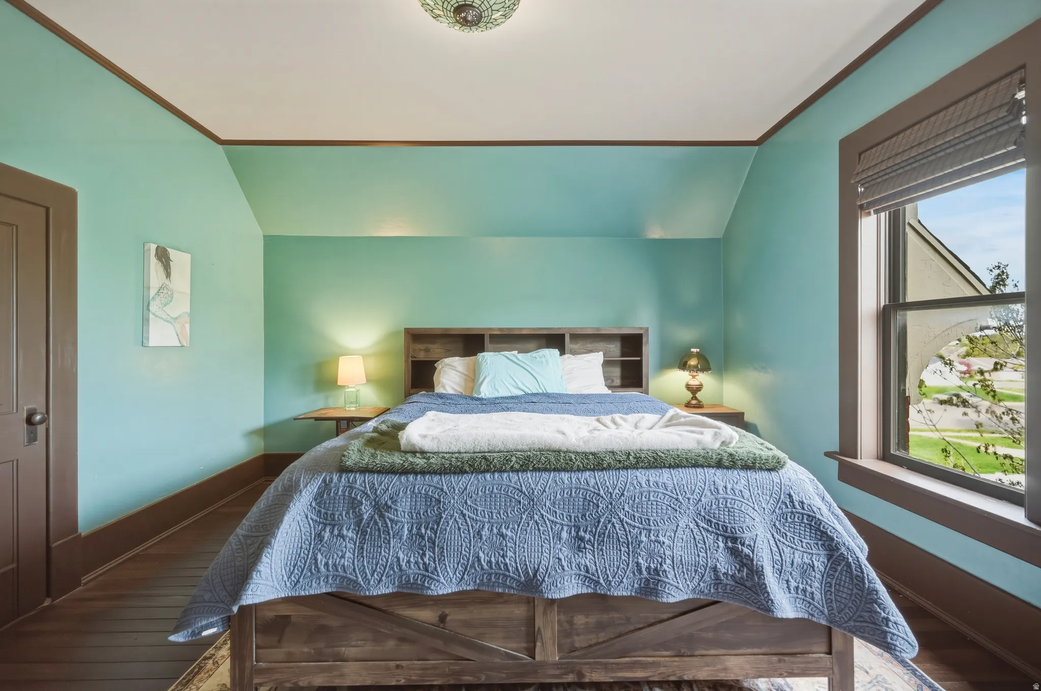 Bedroom with lofted ceiling and view of the backyard, his and her closets