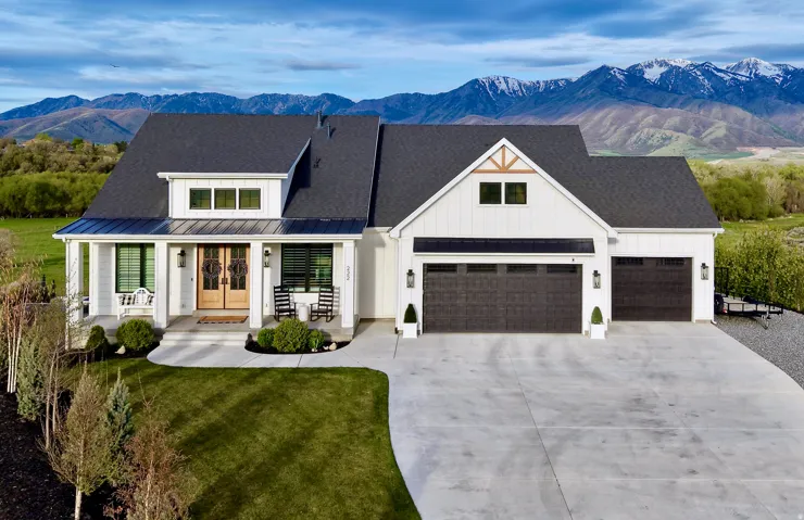 Modern farmhouse with covered porch, french doors, a mountain view, driveway, and board and batten siding