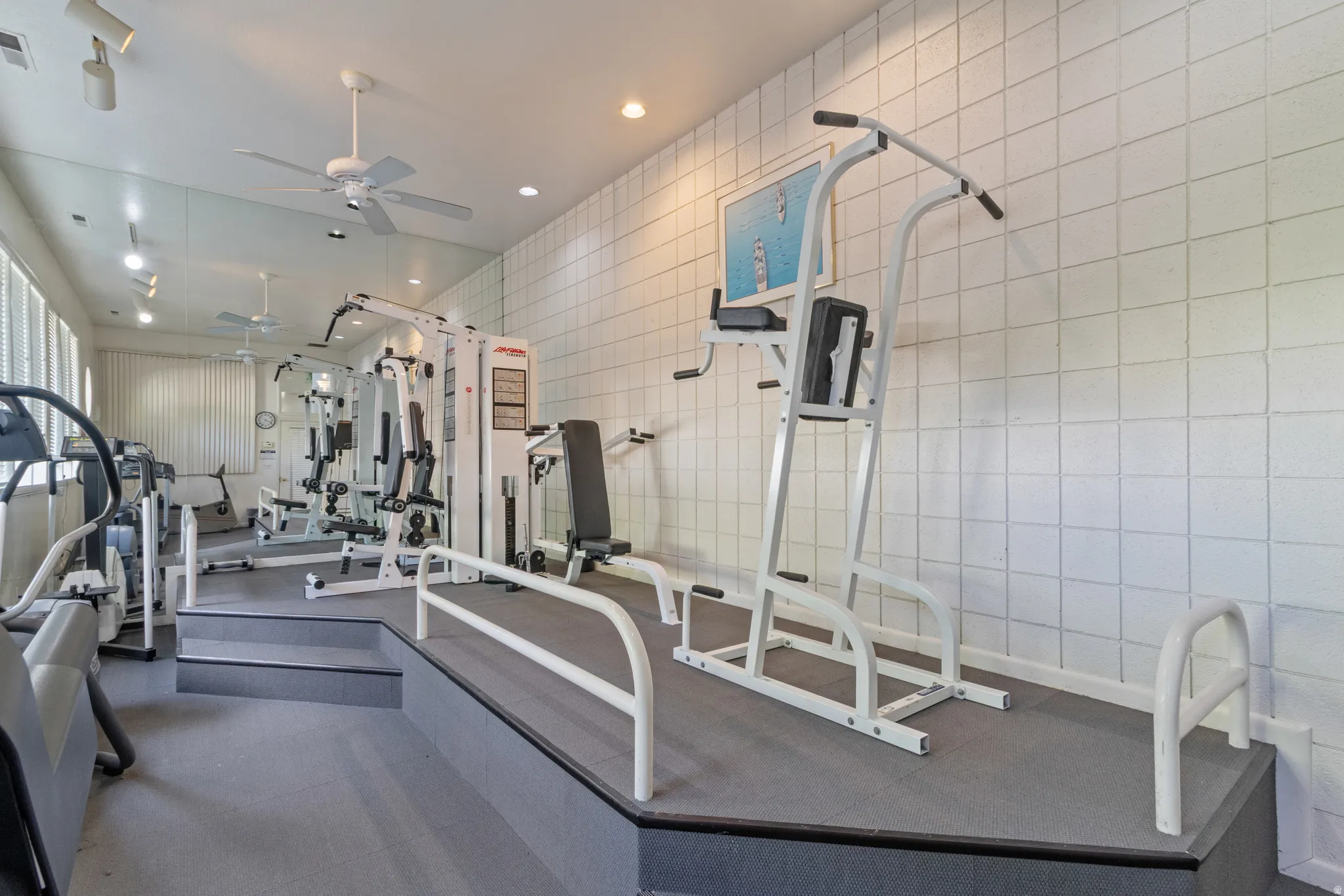 Club house Gym featuring a ceiling fan, recessed lighting, and tile walls