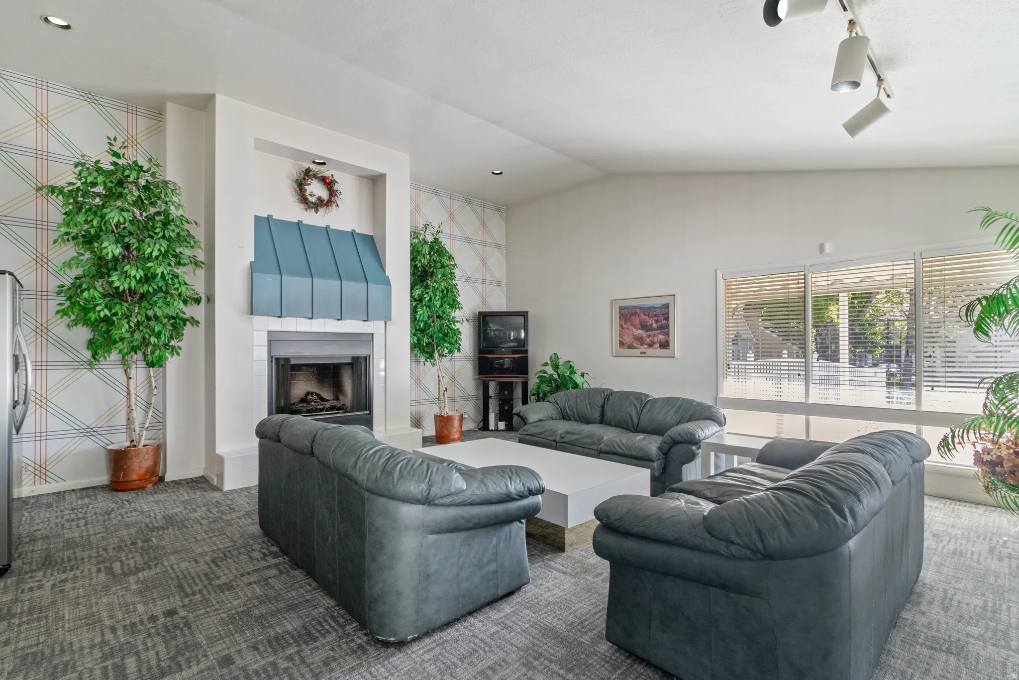 Club House Living area featuring carpet, a fireplace with raised hearth, and lofted ceiling