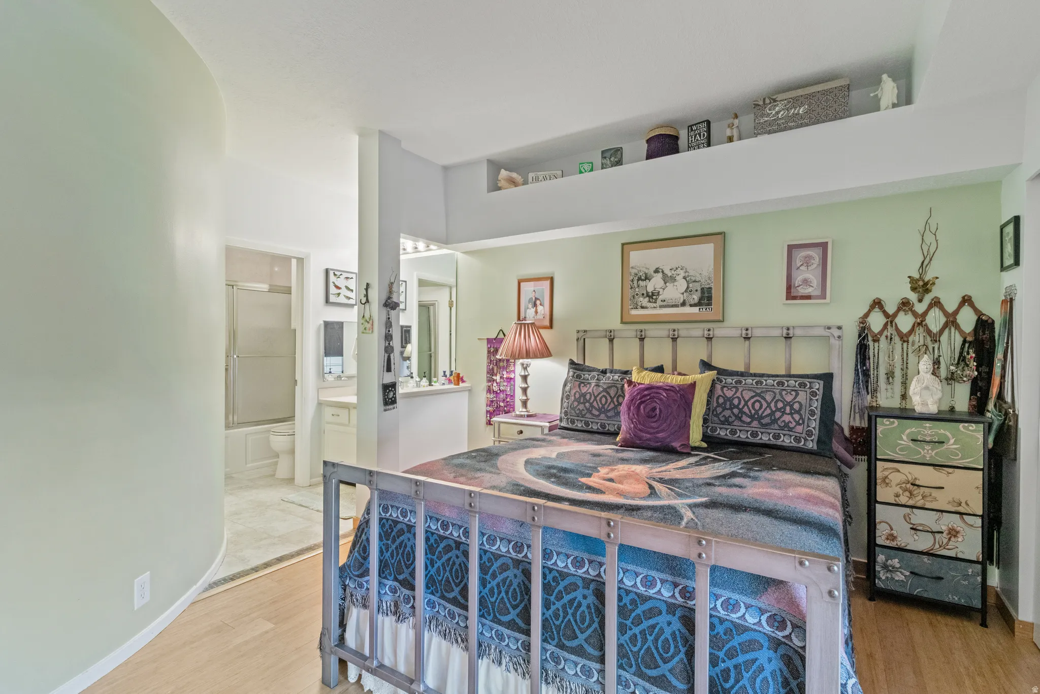 Bedroom with light wood-style flooring and connected bathroom