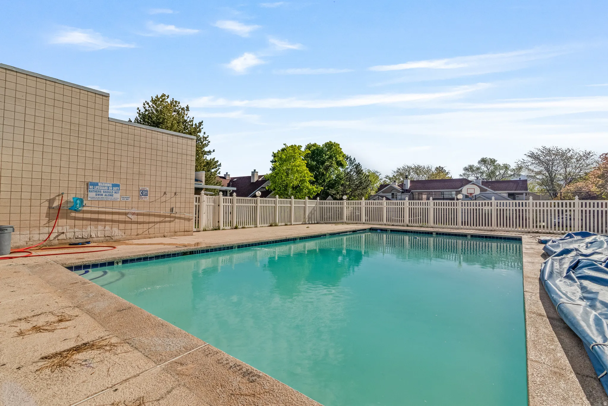 Community pool featuring a patio and a fenced backyard