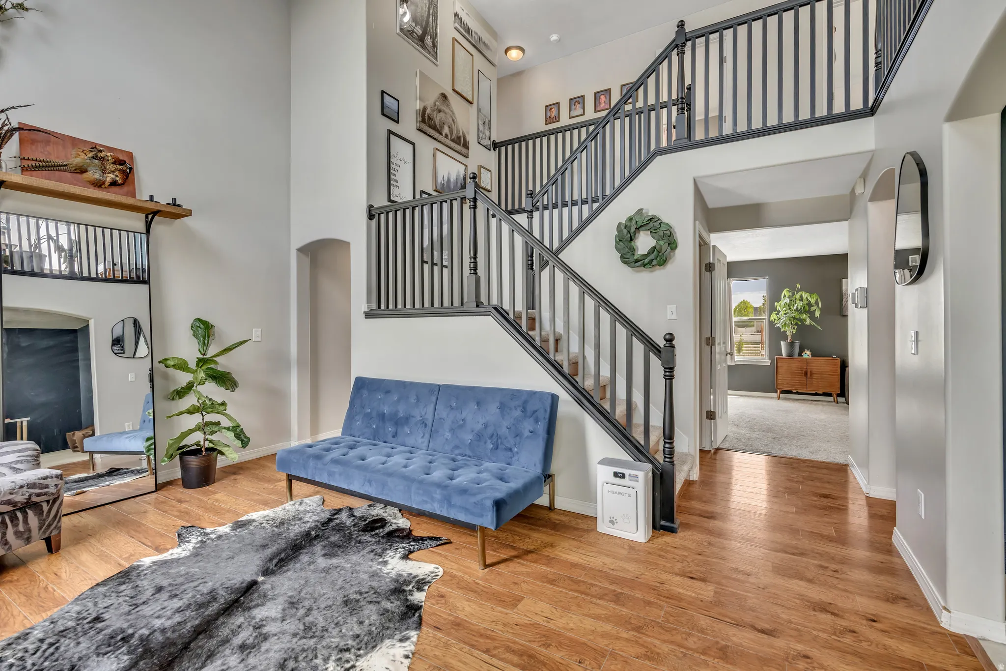 Stairs with arched walkways, a high ceiling, and hardwood / wood-style flooring