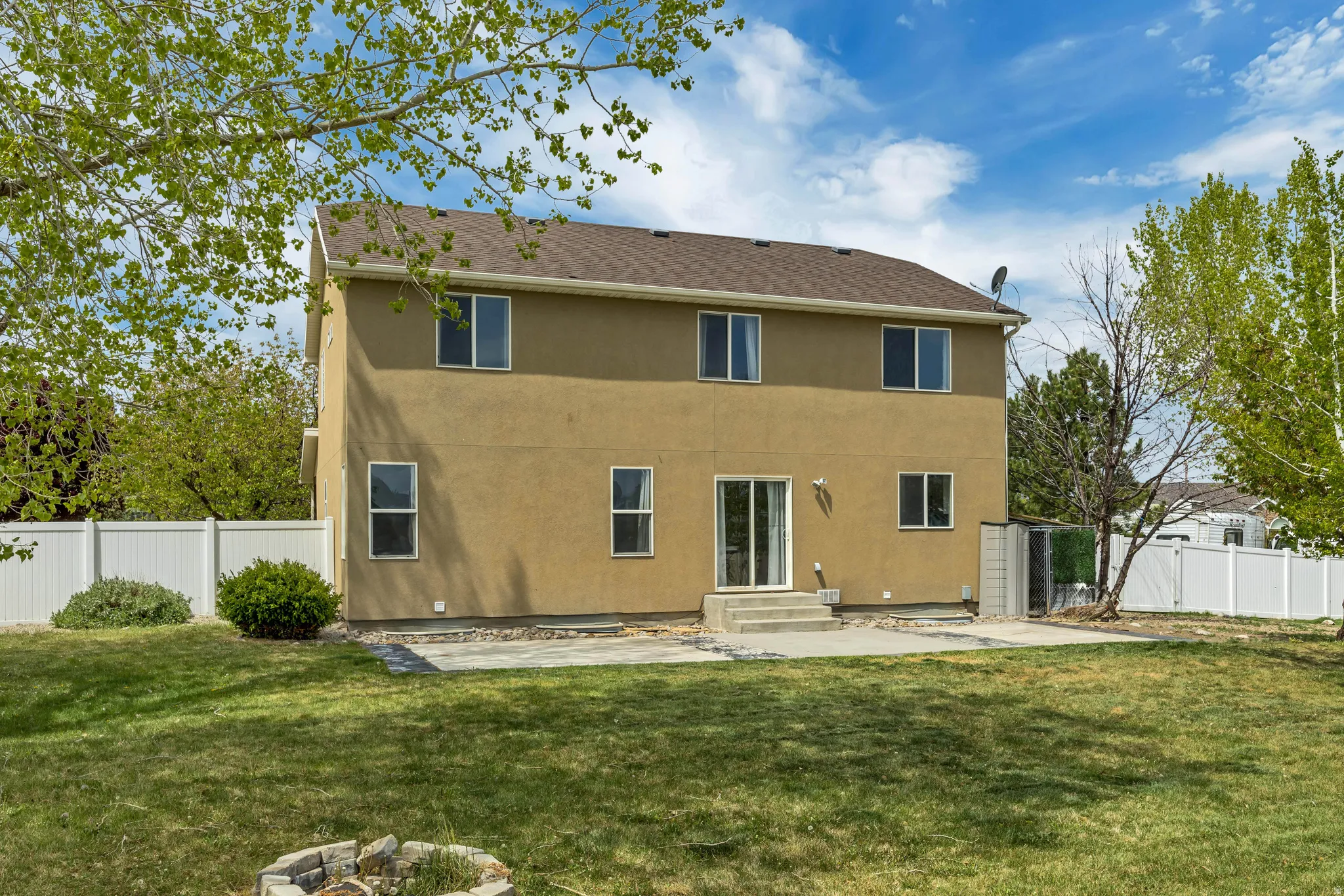 Back of property with a patio, a fenced backyard, stucco siding, and entry steps
