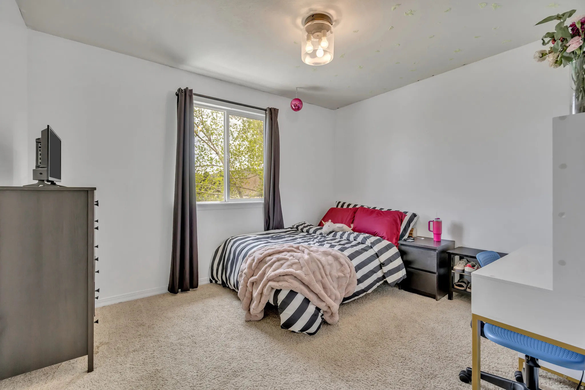 Bedroom with light colored carpet and baseboards