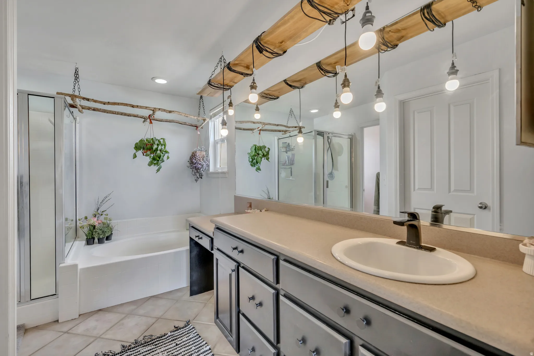 Full bath featuring double vanity, a shower stall, a bath, light tile patterned floors, and recessed lighting