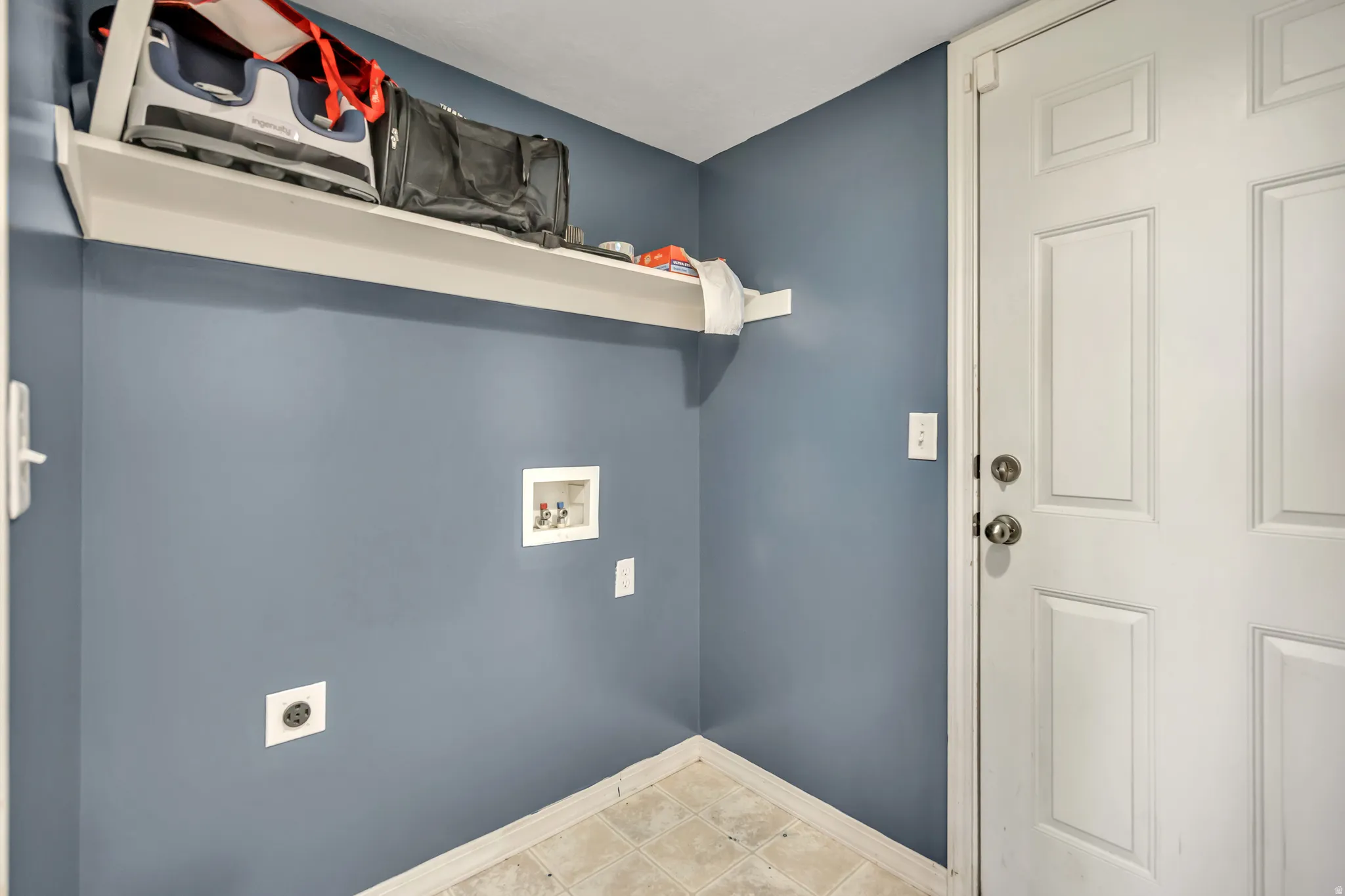 Laundry room with hookup for a washing machine, electric dryer hookup, and light tile patterned floors