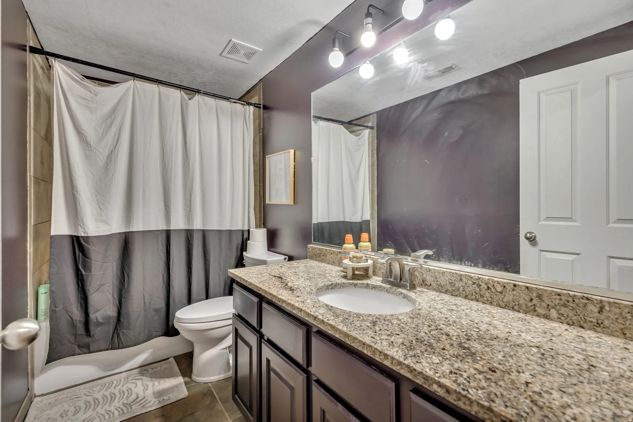 Bathroom with vanity and shower / bath combo with shower curtain