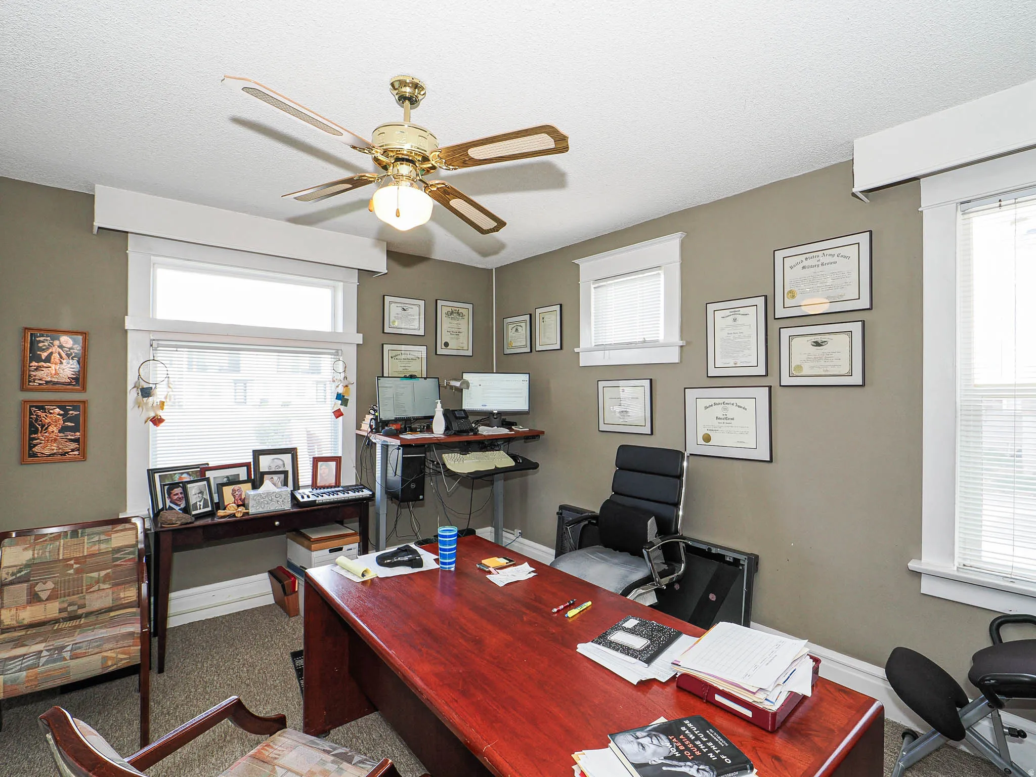 Office area with ceiling fan and a textured ceiling