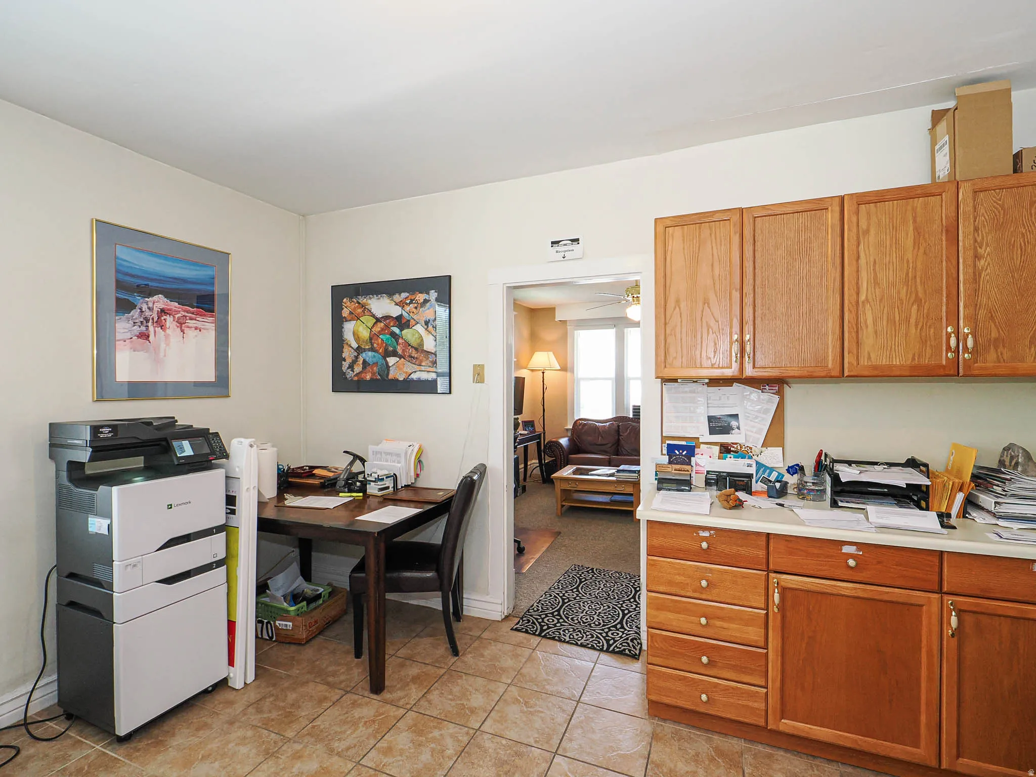 Kitchen featuring light countertops, wood finish cabinets, ceiling fan, and light tile patterned floors