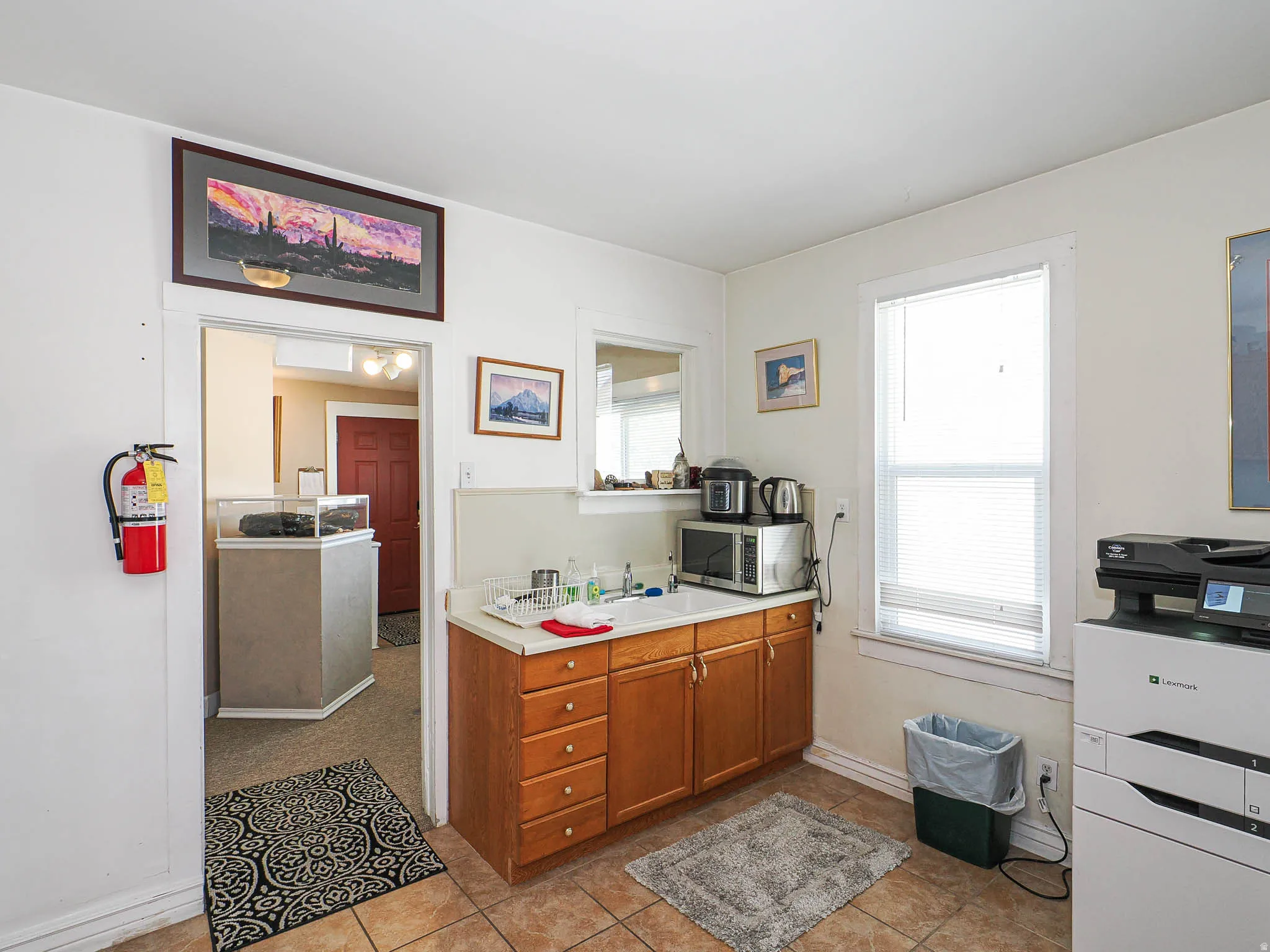 Kitchen featuring light countertops, stainless steel microwave, and wood finish cabinets