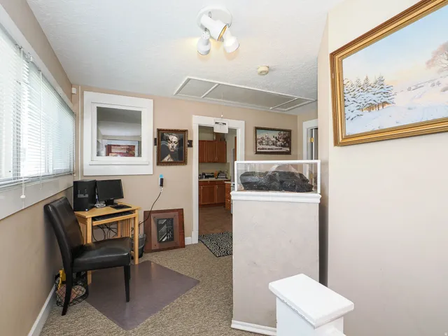 Living area featuring light colored carpet, a textured ceiling, and an office area