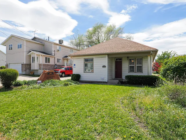 View of front of property featuring roof with shingles and a front yard