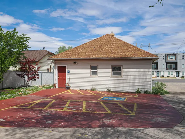 View of front of home featuring a chimney and roof with shingles