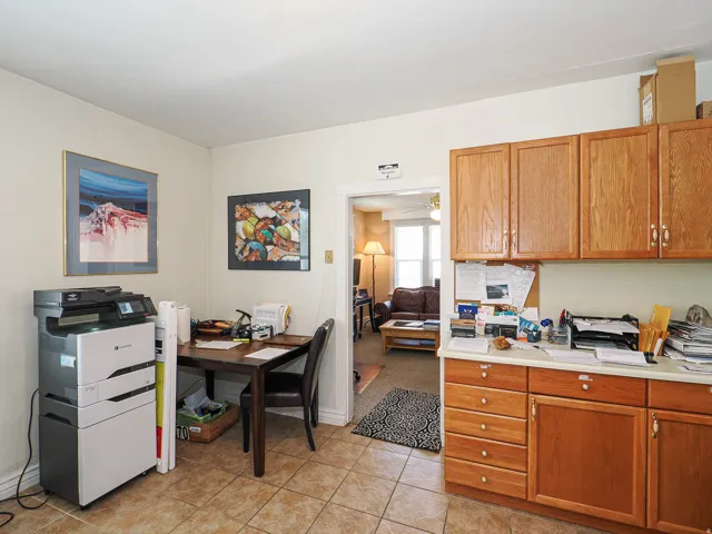 Kitchen featuring light countertops, wood finish cabinets, ceiling fan, and light tile patterned floors