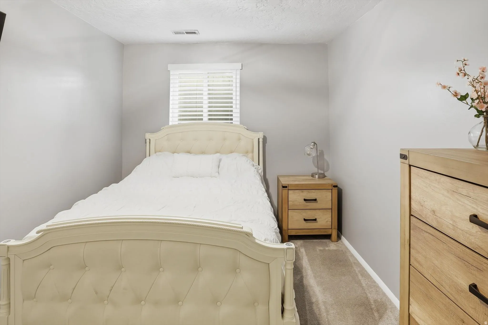 Bedroom with carpet and a textured ceiling