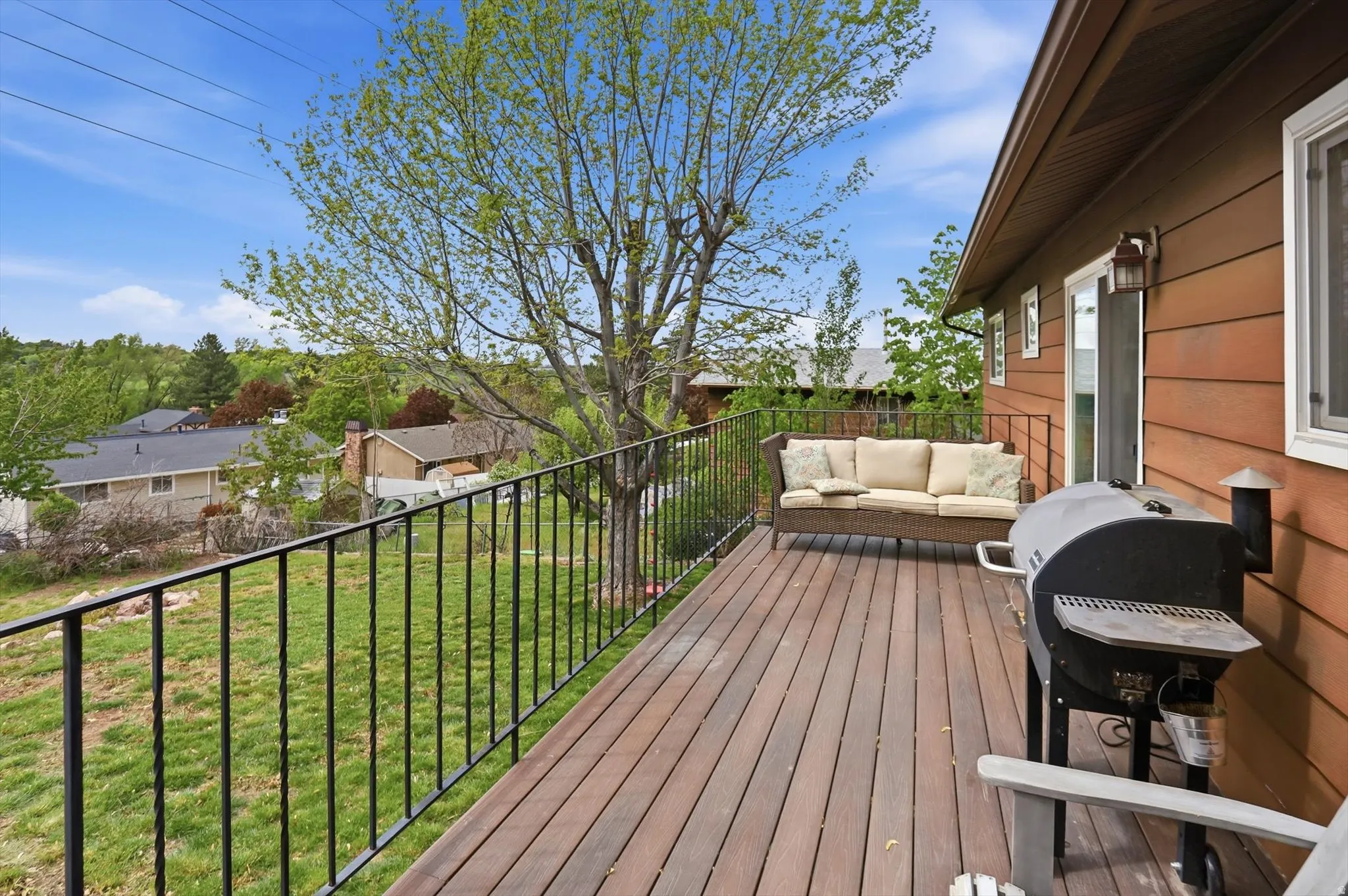 Wooden deck with a grill, a yard, and outdoor seating