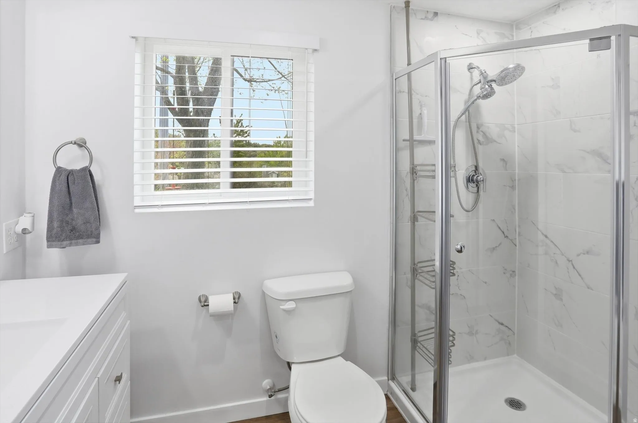 Bathroom featuring vanity and a marble finish shower
