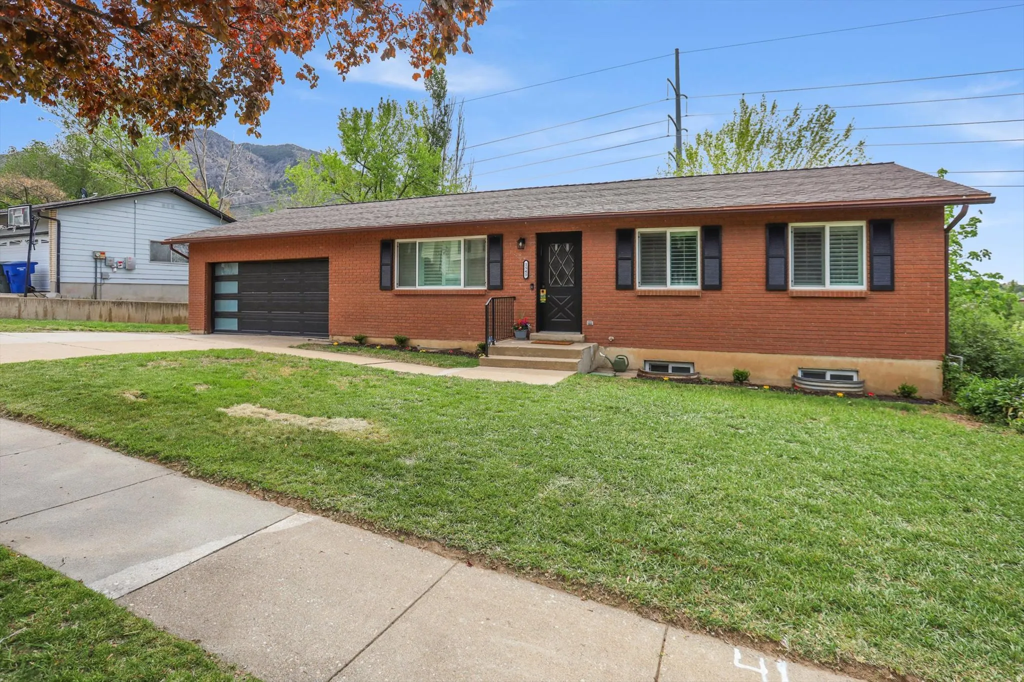 Single story home with brick siding, concrete driveway, a front yard, and a garage