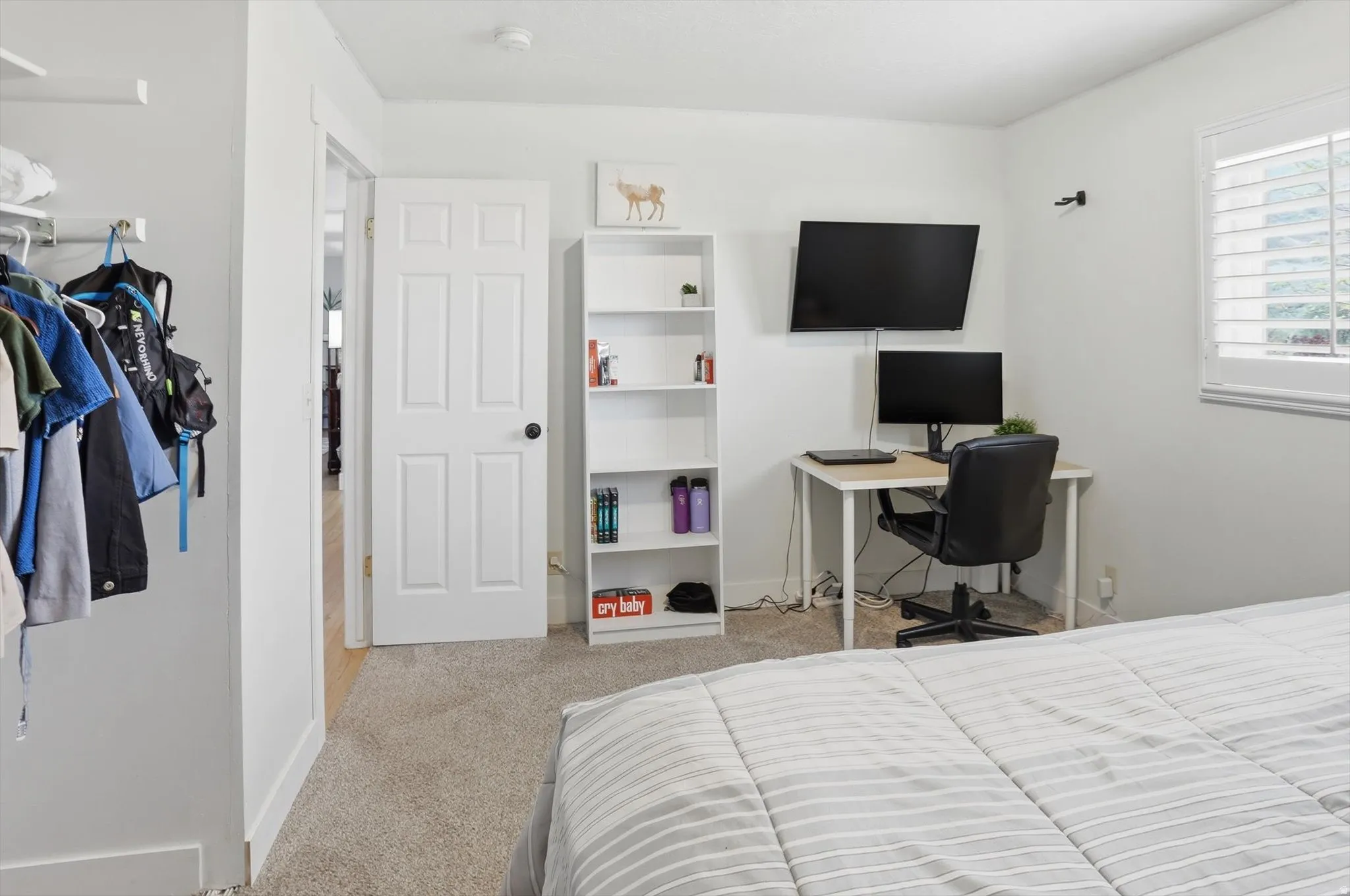 Bedroom with light carpet and a desk