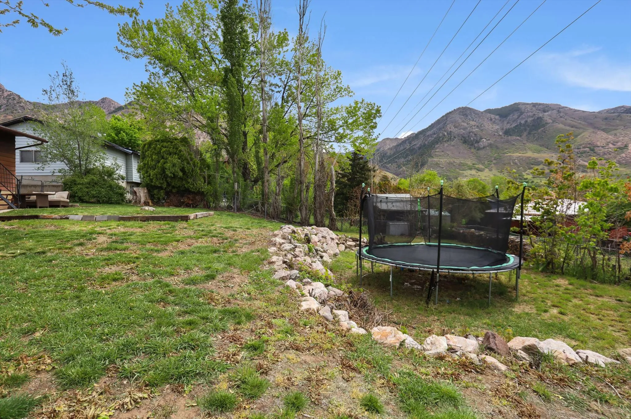 View of yard with a trampoline and a mountain view