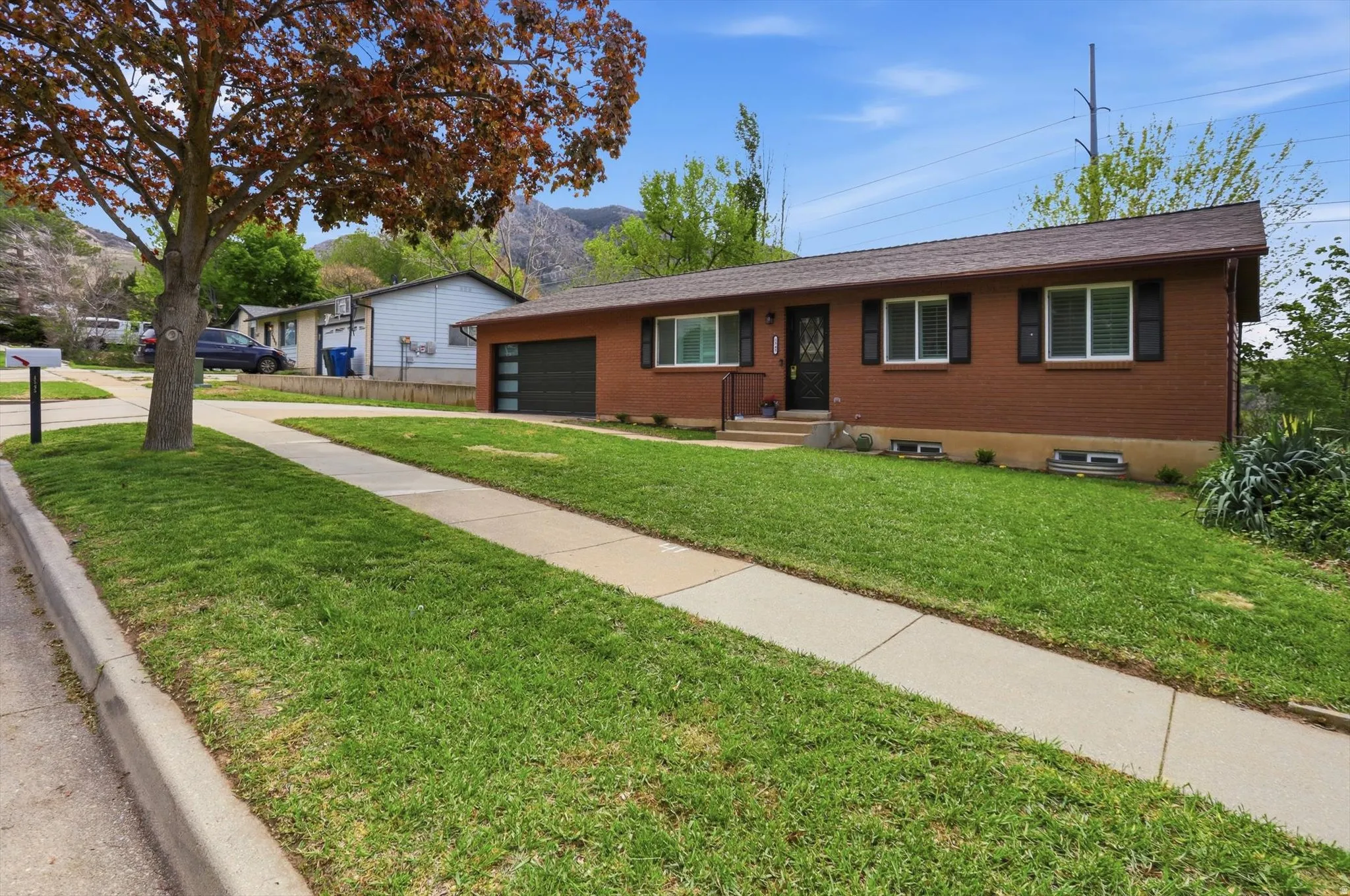 Ranch-style home with brick exterior, a front yard, and a garage