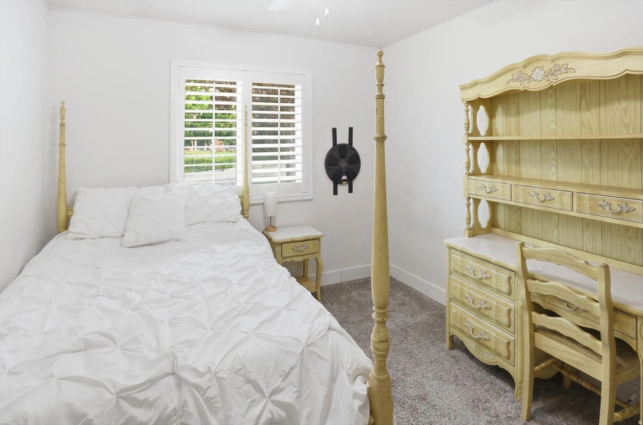 Bedroom with ceiling fan and dark colored carpet