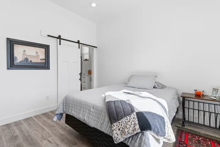 Bedroom featuring a barn door and wood finished floors