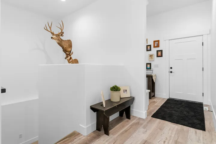 Garage entrance featuring light wood-type flooring and baseboards