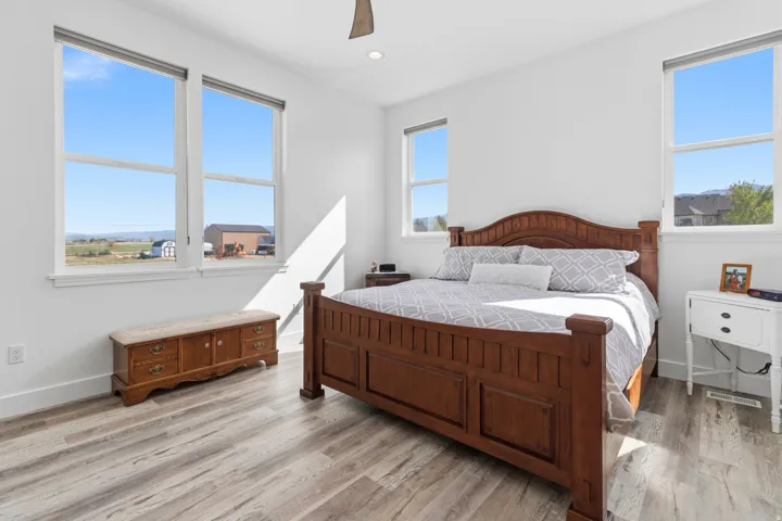 Bedroom with a ceiling fan, light wood-style flooring, multiple windows, and recessed lighting