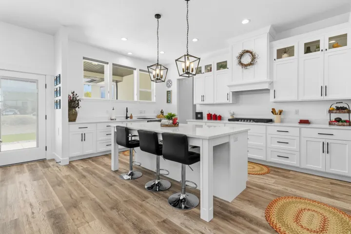 Kitchen with glass fronted cabinets, a center island, a kitchen breakfast bar, white cabinetry, and light wood-style flooring