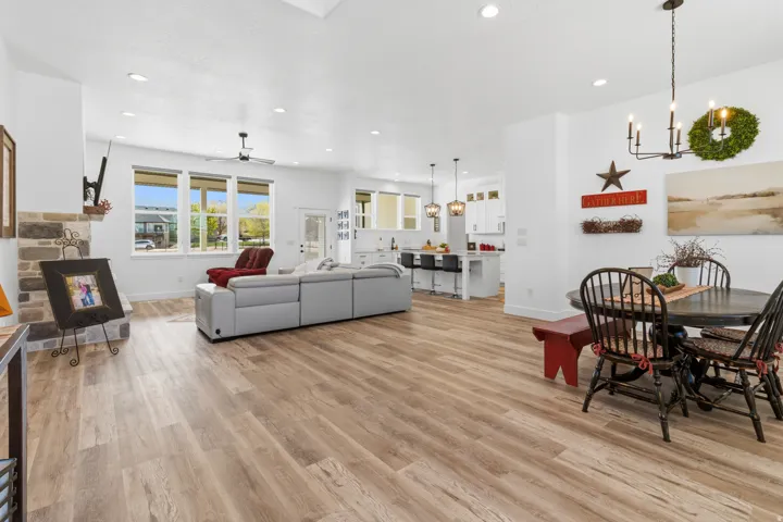 Dining area featuring light wood-type flooring, suspended lighting, and a ceiling fan