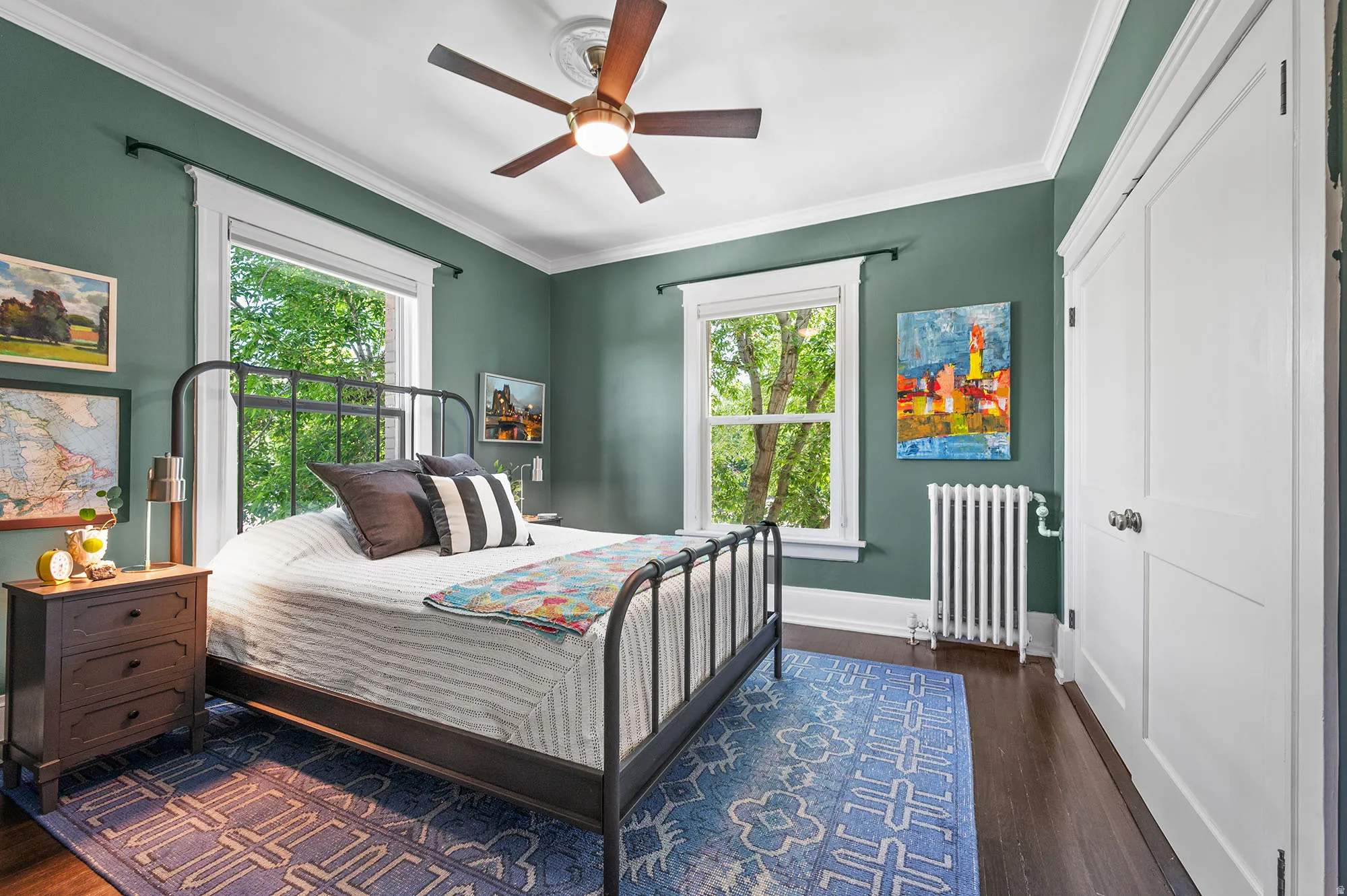 Bedroom with radiator, dark wood finished floors, a ceiling fan, and crown molding