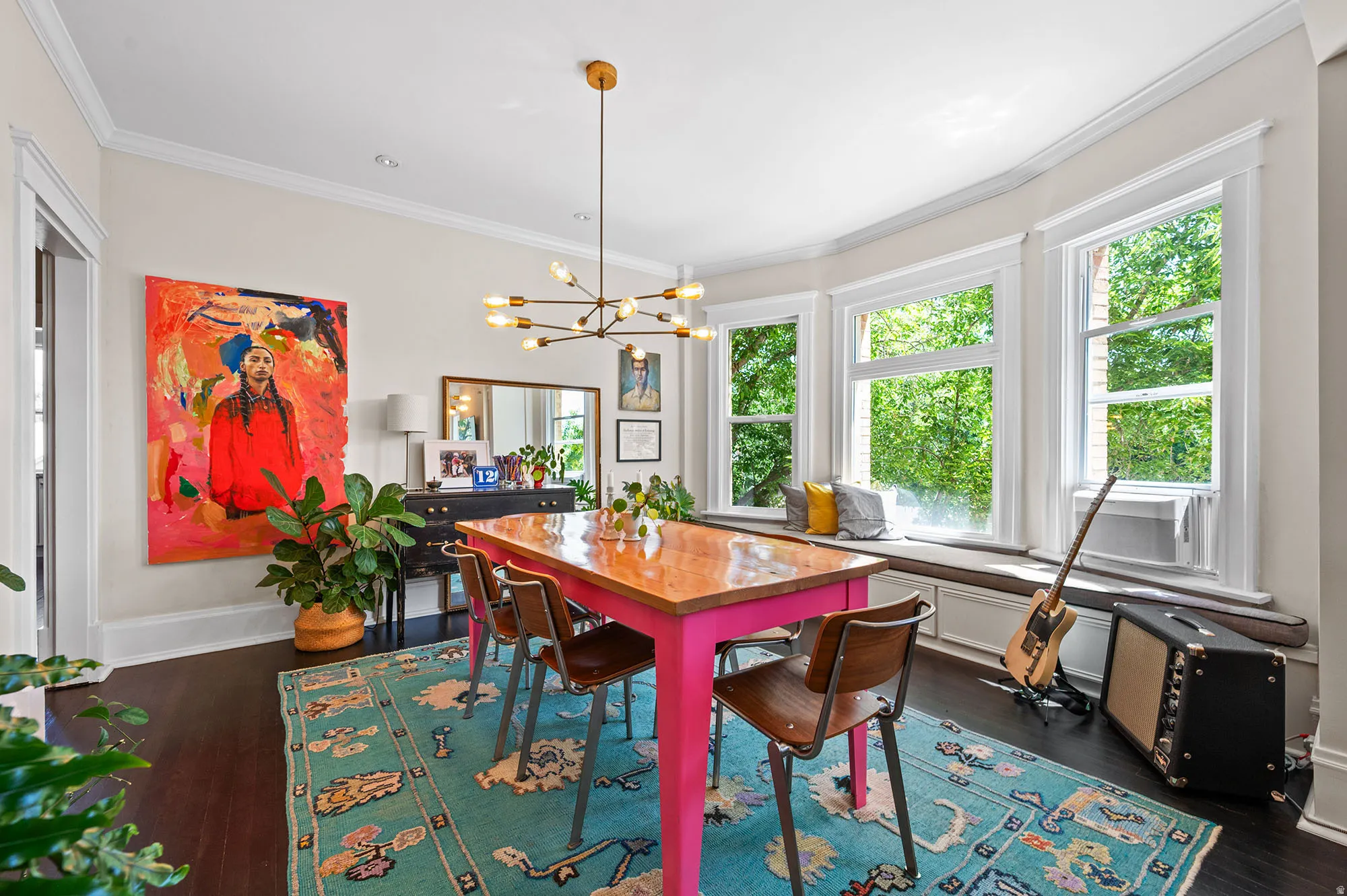 Dining area with a chandelier, dark wood-type flooring, and ornamental molding