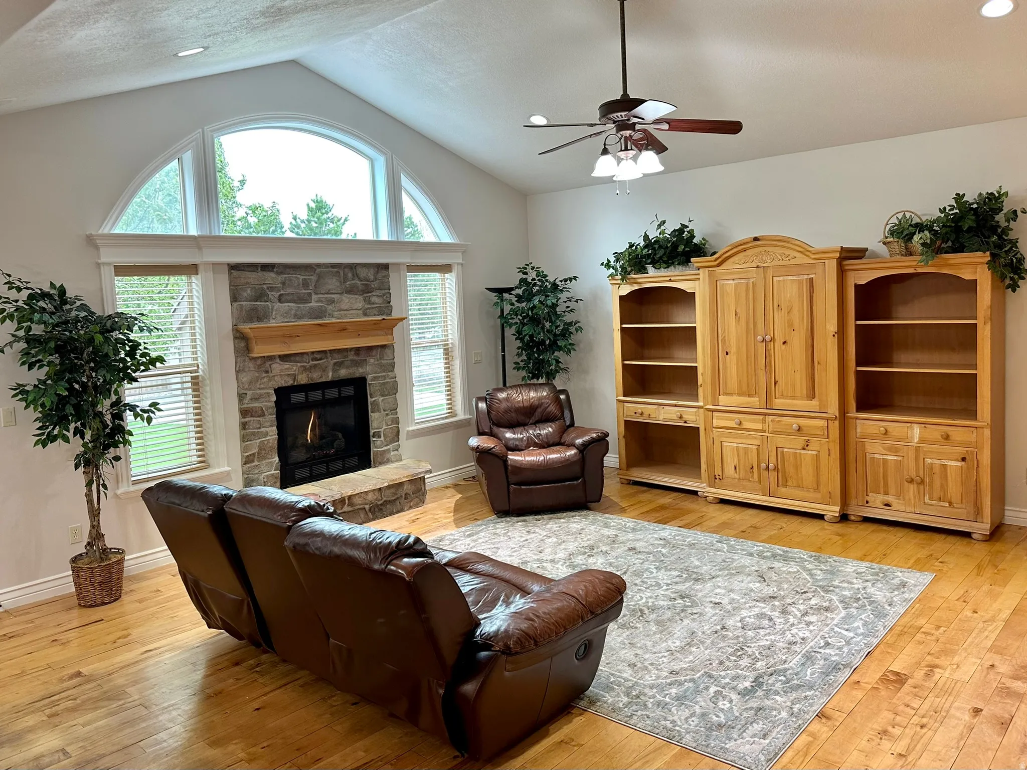 Vaulted ceiling living area featuring hard wood flooring and a ceiling fan and recessed lighting