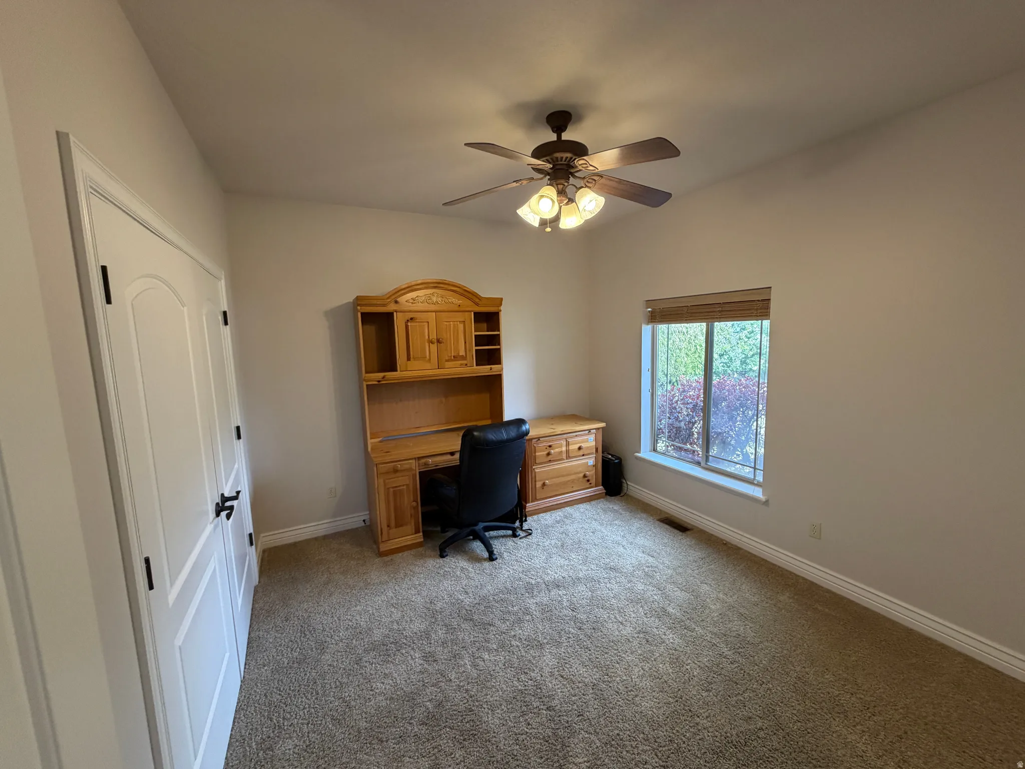 Bedroom with light colored carpet and a ceiling fan